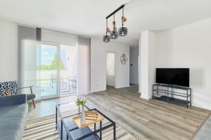 a living room with a couch and a tv at Neubau Luxus Penthouse - Netflix - BBQ in Mannheim +23 photos