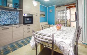 uma cozinha com uma mesa e uma cozinha com paredes azuis em 3 Bedroom Stunning Apartment In Roccaspinalveti em Villa Santa Maria