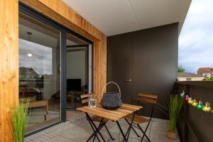 a room with a table and chairs on a balcony at La belle vue in Colmar