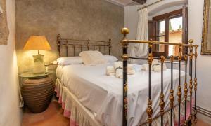 a bedroom with a bed with white sheets and a lamp at Casa rústica en Castell dEmpordà in Corsá