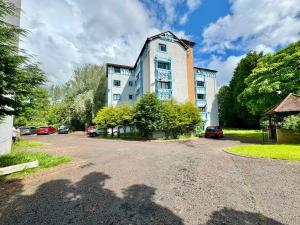 a large building with cars parked in a parking lot at The Alnham, Large 3 bed apartment, Close to the City in Kenton