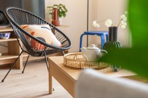 a chair and a table with a tea pot and a vase at La belle vue in Colmar +14 photos