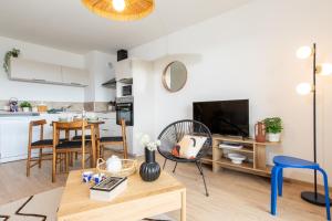 a living room with a table and a kitchen at La belle vue in Colmar