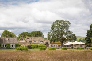 a house with a tree in the middle of a field at The Devonshire Arms Hotel & Spa - Skipton in Bolton Abbey