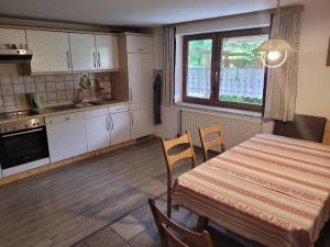a kitchen with a table and chairs and a table and a window at Haus Resi in Eging