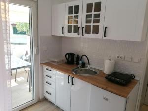 a kitchen with white cabinets and a sink at Crystal Blue Apartments in Nea Kalikratia