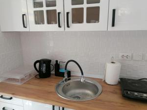 a kitchen counter with a sink and white cabinets at Crystal Blue Apartments in Nea Kalikratia