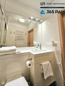 Un baño con lavabo, inodoro y espejo. en Boulevard - 365PAM, en Ustronie Morskie 101 fotos más