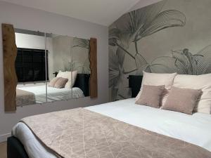 1 dormitorio con cama y espejo grande en Le St Vincent, en Roquefort