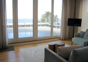 a living room with a large window with a view of a deck at Penthouse Apartment mit Meerblick und Dachterrasse in Gaski bei Mielno in Gąski