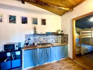 een keuken met een wastafel en een fornuis in een kamer bij Casetta sull’Etna in Nicolosi