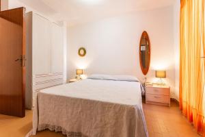 a white bedroom with a bed and a mirror at Villa Agnesina in Solanas