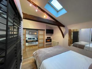 um quarto com uma cama e uma sala de estar em Le St Vincent em Roquefort