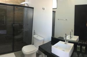 y baño con aseo, lavabo y ducha. en Pousada Lobo Guará, en São João Batista do Glória