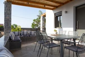a patio with a table and chairs and a couch at Villa Stavelia in Gouves