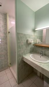 y baño con lavabo y espejo. en The Originals City, Le Logis d'Elbée, Cholet Nord (Inter-Hotel), en Beaupréau