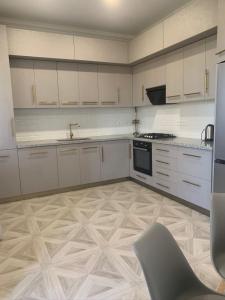 a kitchen with white cabinets and a table and a chair at New house in Jrvezh in Yerevan