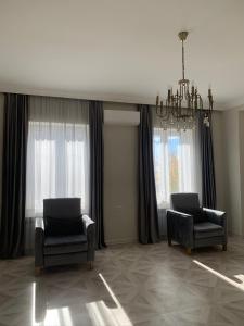 a living room with two chairs and a chandelier at New house in Jrvezh in Yerevan