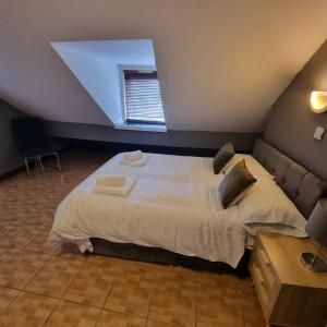 1 dormitorio con 1 cama grande con sábanas y almohadas blancas en Manchester Stay Hotel - Free Parking, en Mánchester