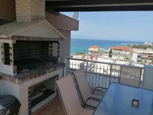 a balcony with a fireplace and a table and chairs at Crystal Blue Apartments in Nea Kalikratia