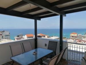 a table on a balcony with a view of the ocean at Crystal Blue Apartments in Nea Kalikratia