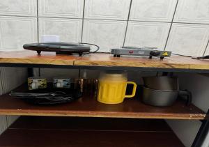 a shelf with a laptop and a yellow mug on it at Residencial Margarida APART 4 in Presidente Figueiredo