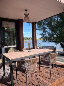 un tavolo e sedie in legno su una terrazza di 10gardens Premium Mobile Homes with private jacuzzi & sauna by OIKO Collection a Privlaka (Brevilacqua)