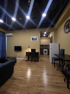 a living room with a couch and a table and a refrigerator at Hotel West in Tbilisi City