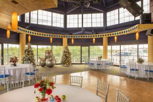 a banquet hall with white tables and christmas trees at Pier 5 Hotel Baltimore in Baltimore