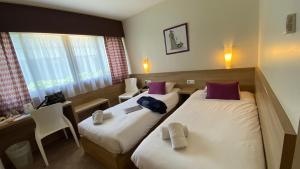 מיטה או מיטות בחדר ב-The Originals City, Le Logis d'Elbée, Cholet Nord (Inter-Hotel)