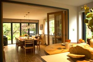 cocina y comedor con mesa y sillas en Modernised seven bedroom country house and garden with hot tub en Cranbrook