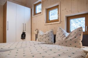 Un dormitorio con una cama con almohadas. en Chalet Sunnseitn - auf der Turracher Höhe en Turracher Hohe