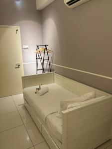 - un lit blanc dans une chambre avec un tripode sur le mur dans l'établissement Modern Suites at Arte Mont Kiara, à Kuala Lumpur