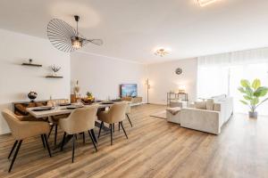 a living room with a table and chairs and a couch at Sky Penthouse 07 I Aufzug I TV I Terrasse I BBQ in Hamm