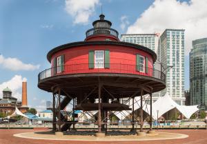 a red lighthouse sitting in the middle of a city at Pier 5 Hotel Baltimore in Baltimore