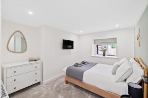 um quarto branco com uma cama e um espelho em Corn Flour Lodge em Dundee