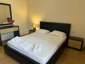 a bedroom with a bed with two towels on it at Grand Park Hotel in Gjirokastër