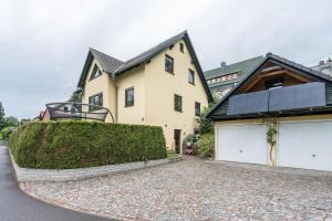 a house with two garage doors and a driveway at Ferienwohnung Erzgebirge in Grünhainichen