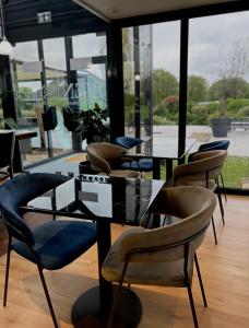 un grupo de sillas y mesas en una habitación con ventanas en Kyriad Deauville - St Arnoult en Deauville