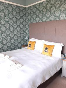 a bedroom with a large white bed with yellow pillows at Laston House in Ilfracombe