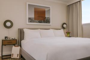溫哥華的住宿－日落套房酒店，卧室设有一张白色大床和一扇窗户。