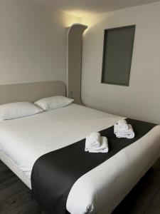 1 dormitorio con 2 camas y toallas en la cama en Kyriad Deauville - St Arnoult en Deauville