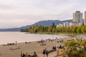 un groupe de personnes sur une plage près de l'eau dans l'établissement Sonder The Sunset, à Vancouver