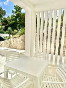 una mesa blanca y sillas en un porche en Petra Maris B&B, en Peschici