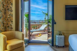 a hotel room with a chair and a sliding glass door at El Avenida Palace in Barcelona