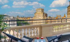 a balcony with two glasses of wine on a table at El Avenida Palace in Barcelona
