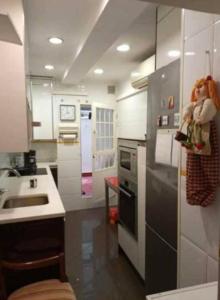 een kleine keuken met een spoelbak en een koelkast bij - Habitación comp Masculina in Madrid