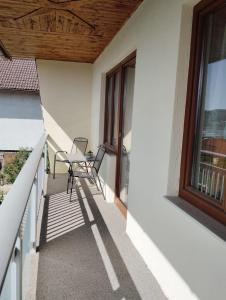 Un balcón de una casa con una silla y una ventana en Donaublick en Marbach an der Donau