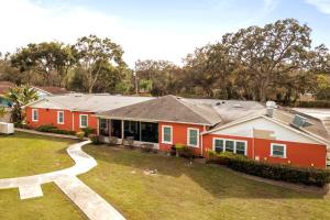a red house with a grass yard at Banana Leaf Villa-Island groove-Standard room in Orlando