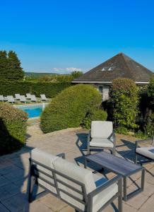 un patio con sillas, una mesa y una piscina en Kyriad Deauville - St Arnoult en Deauville